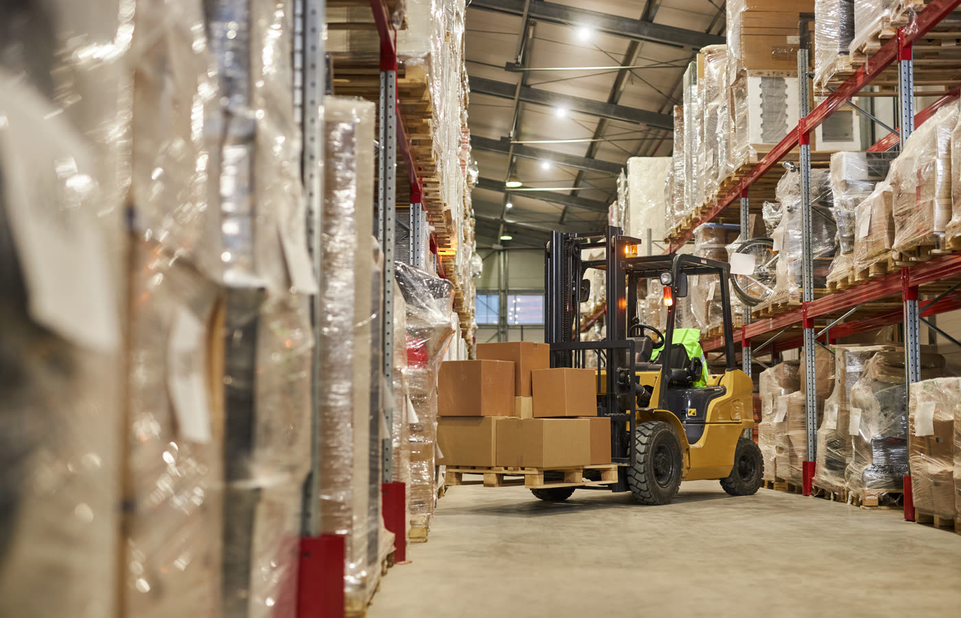 Organised warehouse with shelving, cartons and a forklift